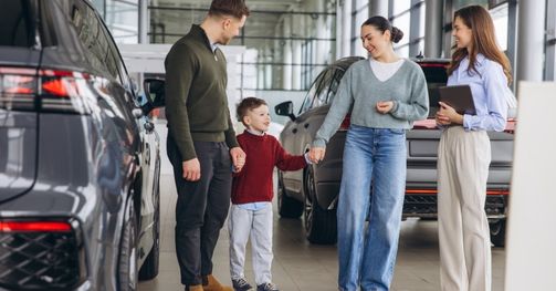Image of a family shopping for an automobile with a salesperson who has a great attitude