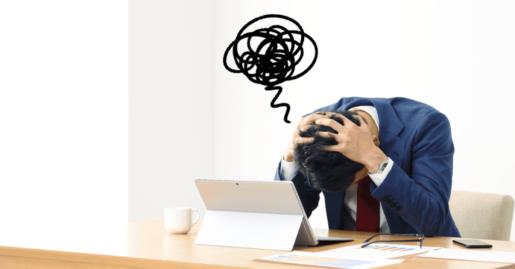 frustrated salesperson has their head in their hands on the desk because their prospect isn't responding