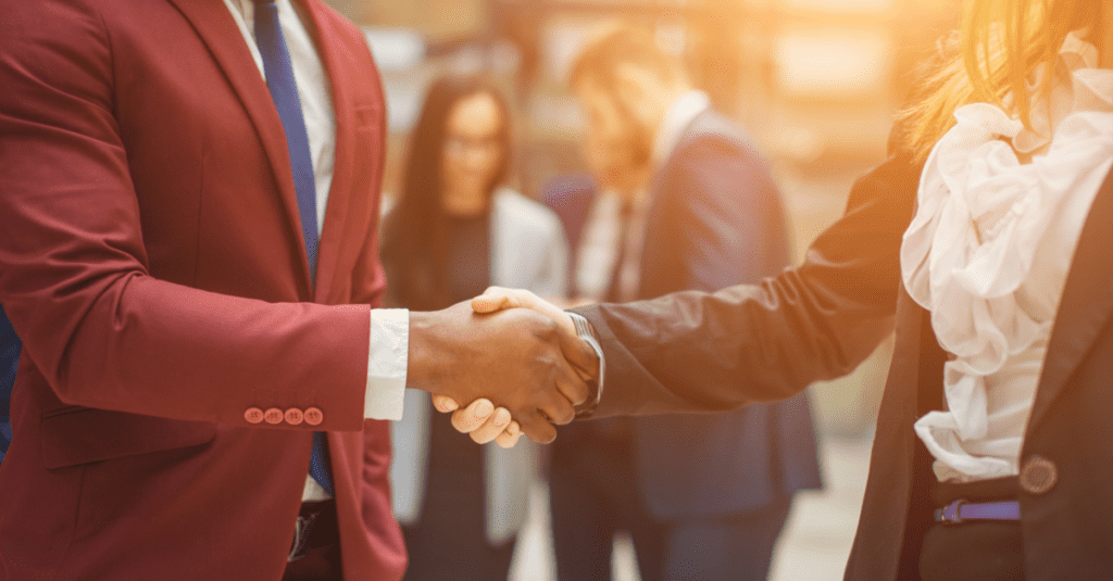 business etiquette two people shaking hands in professional clothing