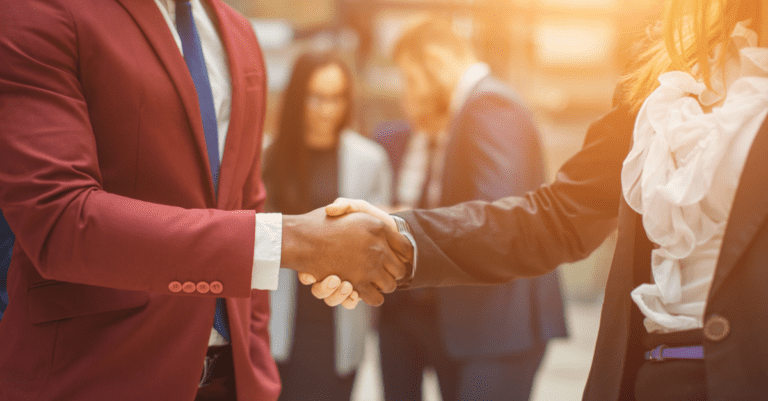 business etiquette two people shaking hands in professional clothing