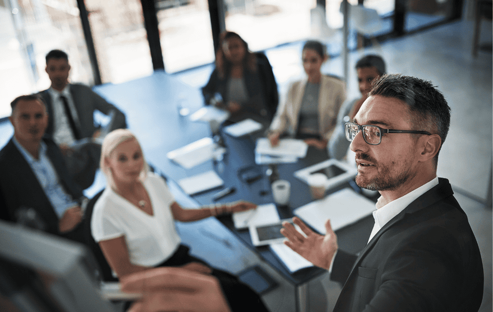 A Sales Gravy expert conducting a group sales team coaching session. Illustrating the process of aligning a sales force under a unified strategy to improve pipeline velocity, team morale, and collective revenue growth.