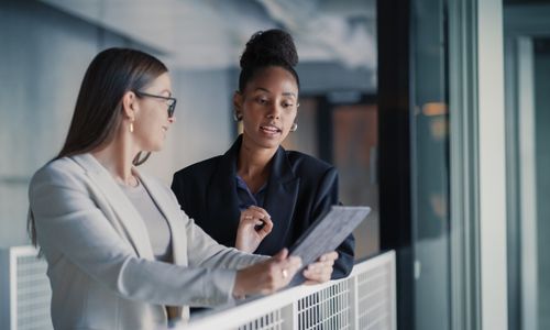 Fractional sales manager coaching a sales rep while reviewing notes on a tablet